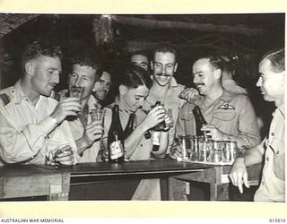 DARWIN, NT. 1943-08-11. AN RAF SPITFIRE SQUADRON IN NORTHERN AUSTRALIA WELCOMES NEW MEMBERS TO THE MESS. LEFT TO RIGHT:- F/LIEUT J. NEWTON RAAF OF BEAUFORT, VIC, F/LIEUT. E.S. HALL RAAF, OF ..