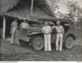VIVIGANI, GOODENOUGH ISLAND, PAPUA. C. 1943-11. MEMBERS OF A RAAF PUBLIC RELATIONS PARTY WITH THEIR VEHICLE. LEFT TO RIGHT: FLIGHT LIEUTENANT (FLT LT) JOHN HARRISON, AN OFFICIAL PHOTOGRAPHER; FLT ..