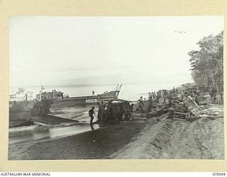 SOUTH BOUGAINVILLE ISLAND. 1945-01-24. TROOPS UNLOADING STORES AT THE BEACH-HEAD OF HEADQUARTERS, 7TH INFANTRY BRIGADE NEAR THE MOUTH OF THE TUJU RIVER DURING THE CHANGE OVER WITH THE 29TH INFANTRY ..