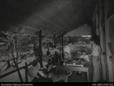 Men dining on the veranda of their accommodation