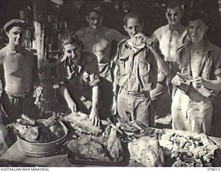 MALMAL VILLAGE, NEW BRITAIN. 1944-12-25. COOKS OF HEADQUARTERS, 5TH DIVISION CARVING UP THE TURKEYS FOR THE UNIT CHRISTMAS DINNER. LEFT TO RIGHT ARE: PRIVATE (PTE) D. S. MAITLAND; SERGEANT J. ..