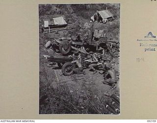 WEWAK AREA, NEW GUINEA. 1945-05-13. MEMBERS OF 1 BATTERY, 2/1 TANK ATTACK REGIMENT IN POSITION BY THEIR 75 MM HOWITZER MOUNTAIN GUN ESTABLISHED AMID THE WRECKAGE OF JAPANESE VEHICLES. THE MEN, ALL ..
