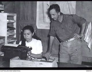 RABAUL, NEW BRITAIN, 1946-03-30. CAPTAIN J.C FITZHERBERT, AUSTRALIAN ARMY MEDICAL CORPS, DICTATING A LETTER TO A CHINESE GIRL TYPIST WHO HAS REPLACED AN AUSTRALIAN ARMY ORDERLY ROOM CLERK AT ..