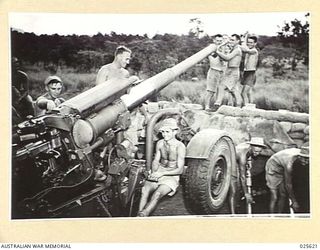 PORT MORESBY, PAPUA. 1942-07. ALWAYS READY. NO TIME IS LOST IN PREPARING ANTI-AIRCRAFT GUNS FOR ACTION AGAIN AFTER JAPANESE RAIDS ON OUR POSITIONS IN NEW GUINEA. THIS PICTURE SHOWS SUN-TANNED ..
