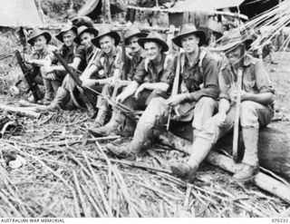 Personnel of the 2/12th Battalion resting at Main Stream. Identified, from left to right: VX69914 Corporal W M Gilbert of Vic; TX4824 Private (Pte) E T T 'Tas' Douglas; Pte J M (Jack) Murray; ..