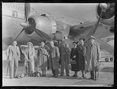 Group of people standing beside the British Commonwealth Pacific Airlines aircraft RMA Endeavour at Whenuapai before White's Fijian tour