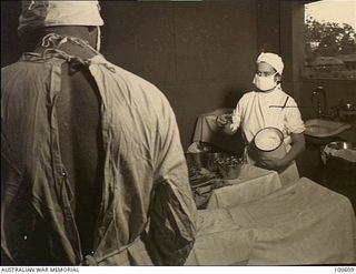 Lae, New Guinea. 1944-08-02. Sister Helen Wilson assisting a medical officer during a surgical operation at 2/7th Australian General Hospital