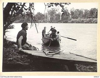 MEVELO RIVER, HENRY REID BAY, NEW BRITAIN, 1945-07-29. MEMBERS OF 2/2 COMMANDO SQUADRON BASED AT LAMANIEN USING AN ENGINEER'S FOLDING BOAT AND LAKATOI, WHICH ARE THE ONLY MEANS AVAILABLE TO CROSS ..