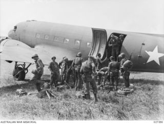 WANIGELA, NEW GUINEA. 1942-10. MEMBERS OF 3RD BATTALION, 128TH REGIMENT, 32ND U.S. DIVISION ALIGHTING FROM A 5TH US ARMY AIR FORCE (USAAF) C-47 TRANSPORT PLANE ON A ROUGH RUN WAY ON THE SHORES OF ..