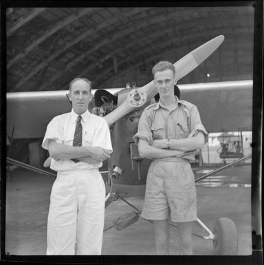 Private aircraft owners, from left, T French and [CPL?] W Tarr in front of plane in hangar, Nausori, Fiji