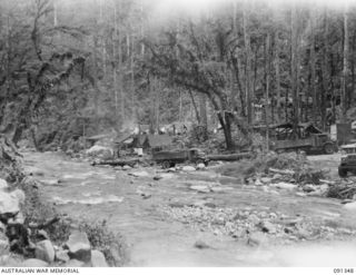 NUMA NUMA TRAIL, BOUGAINVILLE. 1945-04-25. THE ROAD HEAD AT THE FOOT OF BARGES HILL WHERE ALL SUPPLIES FOR 27 INFANTRY BATTALION (AIF) ARE BROUGHT. FROM THIS POINT THEY ARE CARRIED BY NATIVES TO ..