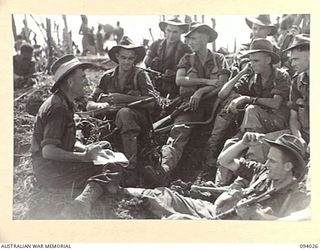 WEWAK AREA, NEW GUINEA, 1945-07-14. MEMBERS OF A COMPANY, 2/8 INFANTRY BATTALION, WHICH ASSAULTED "THE BLOT" WITH B COMPANY IN SUPPORT, ARE INTERVIEWED BY MR L. O'DWYER, WAR CORRESPONDENT (1), AT A ..