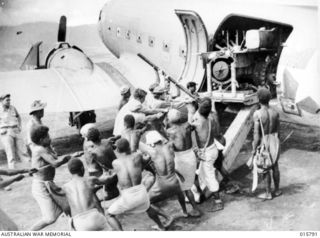 Nadzab, Markham Valley, New Guinea. 1943-09. Equipment for the allied drive on Lae being unloaded on Nadzab airstrip