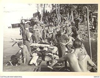 JABA RIVER AREA, BOUGAINVILLE, SOLOMON ISLANDS. 1944-12-18. D COMPANY, 15 INFANTRY BATTALION SUPPORT TROOPS UNLOADING GEAR FROM A BARGE AFTER THEIR UNSUCCESSFUL ATTEMPT TO NEGOTIATE THE RIVER TO ..