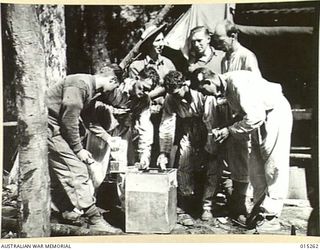 1943-07-14. NEW GUINEA. WAU-MUBO AREA. PATIENTS AT A FORWARD DRESSING STATION RECEIVE RED CROSS COMFORTS. (NEGATIVE BY G. SHORT)