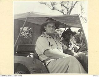 TOROKINA, BOUGAINVILLE ISLAND. 1944-12-15. VX244 MAJOR H. MCP. AUSTIN, ASSISTANT PROVOST MARSHAL, HEADQUARTERS, 2ND AUSTRALIAN CORPS (1) AND HIS DRIVER, NX87215 DRIVER E. NOLAN (2) PREPARE TO ..