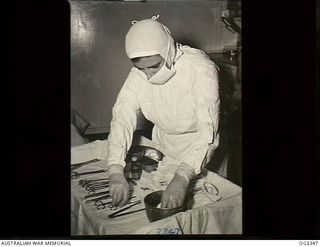 MADANG, NEW GUINEA. C. 1945. 500260 SISTER G. MCNAMARA, LEONGATHA, VIC, WHO IS THEATRE SISTER AT NO. 1 MEDICAL RECEIVING STATION RAAF, PREPARES AND STERILIZES INSTRUMENTS FOR A SURGICAL OPERATION