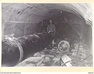 RABAUL, NEW BRITAIN. 1945-11-20. JAPANESE TORPEDOES MOUNTED ON RAIL TRACKS IN A CONCRETE TUNNEL AT THE SITE OF THE FORMER JAPANESE NAVAL HEADQUARTERS