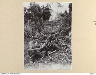 ULUPU, NEW GUINEA, 1945-07-09. PTE W.E. WILBY (1) AND PTE H.I. RODD (2), MEMBERS OF D COMPANY, 2/5 INFANTRY BATTALION, EXAMINING A JAPANESE TYPE 92 "WOODPECKER" MACHINE-GUN THAT HELD UP THE ..