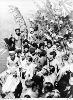 Pacific Area No. 23. 1944-12-25. HMAS Benalla crew played host for a Christmas Party for natives from a small Pacific Island. Presents were given to about 100 men, women and children by Father Xmas ..