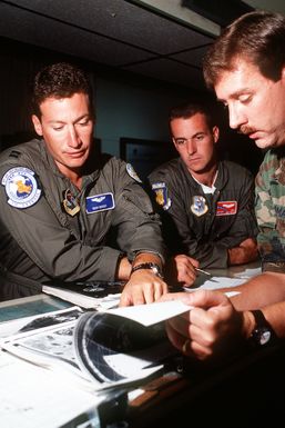 STAFF SGT. Gordon Chapman, left, Det. 2, 20th Weather Squadron, gives a briefing to CAPT. Richard Burger, left, KC-10A Extender aircraft commander and co-pilot 1ST LT. Mike Mathews in the base operations center. The pilots, with the 6th Air Refueling Squadron, 22nd Air Refueling Wing, are on a Military Airlift Command channel cargo mission