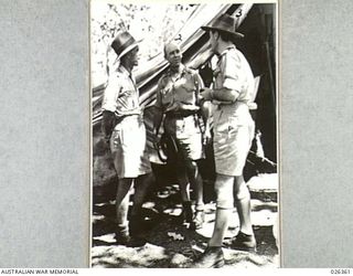 NEW GUINEA. 1942-08-04. LIEUTENANT CHAMPION RESIDENT OFFICER AT BUNA (LEFT) AND SERGEANT BISHOP, OF THE 1ST PAPUAN INFANTRY BATTALION, THE FIRST MEN TO SIGHT THE JAPS AT BUNA, BEING QUESTIONED BY ..