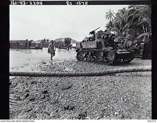 BONIKA, BRITISH SOLOMON ISLANDS PROTECTORATE. C.1944. AMMUNITION FOR AN M3 STUART TANK (MC60380) OF THE US MARINE CORPS IS BROUGHT ASHORE FROM A LANDING CRAFT OF AN US NAVY ATTACK TRANSPORT. (NAVAL ..