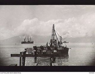 MILNE BAY, NEW GUINEA, 1943-07-11. 4TH AUSTRALIAN FIELD COMPANY, ROYAL AUSTRALIAN ENGINEERS, PILE-DRIVERS AT WORK BUILDING A 860 FEET LENGTH AND 400 FEET WIDTH "T" JETTY. HALF-CAPS AND CORBELS ARE ..