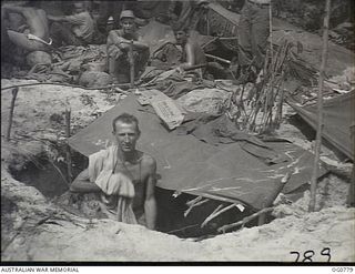 MOMOTE, LOS NEGROS ISLAND, ADMIRALTY ISLANDS. 1944-03-18. LEADING AIRCRAFTMAN E. G. WRIGHT, ROSEWOOD, QLD, A COOK, IN THE FOXHOLE IN WHICH HE SPENT HIS FIRST NIGHT ASHORE. RAAF MEMBERS OF THE UNIT ..