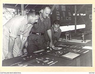 JACQUINOT BAY, NEW BRITAIN. 1945-06-06. MAJOR BATES, DISTRICT OFFICER, NEW BRITAIN (1), LIEUTENANT COLONEL GRIFFIN, ASSISTANT QUARTERMASTER, 5 DIVISION (2) AND DRIVER G.A. COWLEY, HEADQUARTERS 5 ..