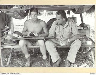 1943-05-17. NEW GUINEA. GONA. LIEUT. R.B. HODGSON OF VAUCLUSE, SYDNEY, N.S.W. WELL KNOWN MANLY AND NORTH BONDI SURF CLUBS MEMBER WITH GUNNER D. PINNINGTON OF ROSEVILLE, N.S.W. (CLEANING RIFLE). ..