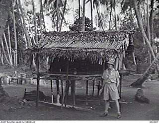 ORO BAY, NEW GUINEA. 1943-01. EXTERIOR OF THE PRIMITIVE NATIVE TYPE STRUCTURE THAT SERVED AS THE ORIGINAL QUARTERS OF THE BEACHMASTER. (NAVAL HISTORICAL COLLECTION)