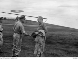 RABAUL, NEW BRITAIN. 1945-12-28. THE PRIME MINISTER OF AUSTRALIA, MR BEN CHIFLEY, ARRIVED BY PLANE TO VISIT MANY OF THE UNITS IN THE AREA. MR CHIFLEY IS GREETED BY MAJOR GENERAL EATHER, COMMANDING ..