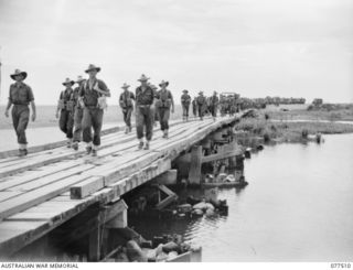 BOUGAINVILLE ISLAND. 1944-12-06. TROOPS OF A COMPANY, 15TH INFANTRY BATTALION WALKING ACROSS THE BRIDGE OVER THE TOROKINA RIVER AS THEY PROCEED TO THE FORWARD AREAS TO RELIEVE PERSONNEL OF THE 1ST ..