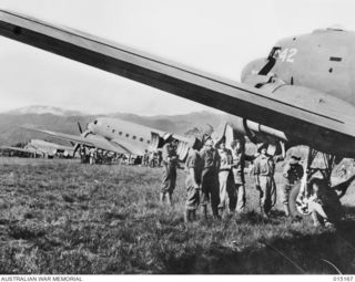 1943-06-29. NEW GUINEA. WAU-MUBO AREA. TRANSPORT PLANES UNLOADING AT AN ADVANCED LANDING GROUND. (NEGATIVE BY G. SHORT)