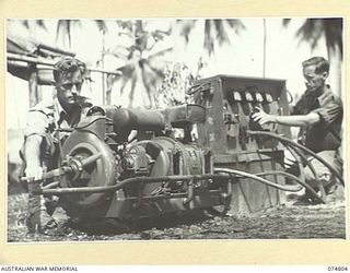 MILILAT, NEW GUINEA. 1944-07-16. SIGNALS PERSONNEL OF HEADQUARTERS, 5TH DIVISION TESTING THE POWER GENERATING PLANT OF A CAPTURED JAPANESE MODEL 94, TYPE 2, 300 WATT, RADIO TRANSMITTER