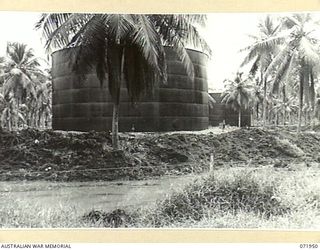 MILNE BAY, PAPUA, NEW GUINEA. 1944-04-03. A 500,000 GALLON OIL TANK, ONE OF SEVERAL TANKS LOCATED AT THE 2ND BULK PETROLEUM STORAGE COMPANY. THE SOIL SURROUNDING THE TANK HAS BEEN FORMED BY A ..