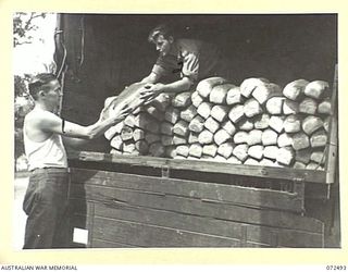 PORT MORESBY, NEW GUINEA. 1944-04-20. VX120215 PRIVATE K.M. ANDREWARTHA, 6TH FIELD BAKING PLATOON (1), ASSISTED BY Q149156 DRIVER M.T. MCNAMARA, 131ST GENERAL TRANSPORT COMPANY (2), LOADING 4 POUND ..