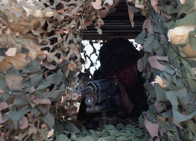 SPECIALIST (SPC) Alexander Reitan, US Army (USA), 1ST Battalion, 17th Infantry Division mans a 7.62mm M240G Machine Gun inside a camouflaged bunker as he secures an area at Orote Point, Guam during Exercise TANDEM THRUST '99