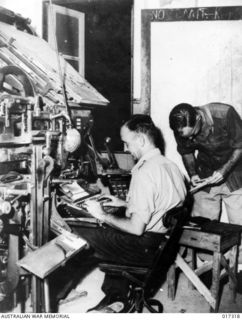 New Guinea. 1944. Corporal R. Holzberger and Private A. Garsden both of Brisbane, Qld, setting the type for the printing of "Guinea Gold" the newspaper distributed daily to the troops in New Guinea