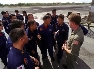 United States Aviation Electronics Technician (AW/NAS) Scott A. Wells (right) from squadron VP-47 answers questions posed by Republic of Korea Navy (ROKN) LT Lee Gun Chul (with book in hand) and his crew of squadron VP-613 during the exercise RIMPAC '98