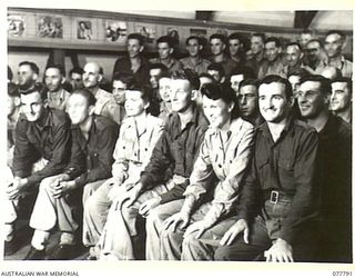 LAE BASE AREA, NEW GUINEA. 1944-12-27. AUSTRALIAN SERVICE PERSONNEL WATCHING THE CHRISTMAS CONCERT STAGED IN THE AUDITORIUM OF THE 22ND WORKS COMPANY