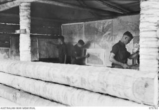 SIAR-NAGADA, NEW GUINEA. 1944-09-08. Q108244 LANCE-CORPORAL P.A. PENDER (1) QX56631 SERGEANT D.H. SUMMERS (2) AND QX56630 LANCE SERGEANT S.R. IRVINE (3) WORKING IN THE OPERATIONS AND BATTLE ROOM, ..