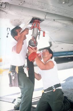 Members of the Hawaii Air National Guard attach a fuel hose to an aircraft