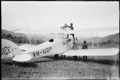 Refuelling De Havilland Moth VH-UQP by kerosene tin, operated by Carpenters, Salamaua, New Guinea, 1933, 2 / Sarah Chinnery