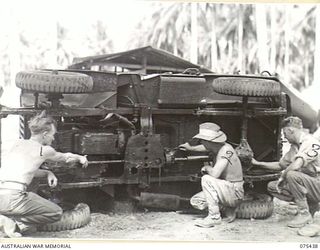 MILILAT, NEW GUINEA. 1944-08-22. PERSONNEL OF THE AUSTRALIAN ELECTRICAL AND MECHANICAL ENGINEERS, HEADQUARTERS, 5TH DIVISION GREASING AND WATERPROOFING AN AUSTRALIAN ARMY JEEP DURING EXPERIMENTS IN ..