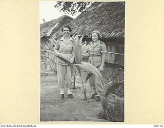 AITAPE, NEW GUINEA. 1945-03-20. SISTER E.L. CLARKE (1), AND SISTER B.A. HEWSON (2), MEMBERS OF THE AUSTRALIAN ARMY NURSING SERVICE, IN THE GARDEN OUTSIDE THE OFFICERS WARD, 2/11 GENERAL HOSPITAL