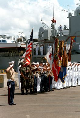 A joint service honor guard and color bearers salute the Unknown Serviceman of the Vietnam Era as his casket is carried aboard the frigate USS BREWTON (FF 1086) for transport to California. The casket will be transferred to Arlington National Cemetery for interment at the Tomb of the Unknowns