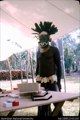 Man in traditional dress collecting ballot paper