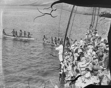 [Crowd on ship watch Pacific Islanders in canoes]